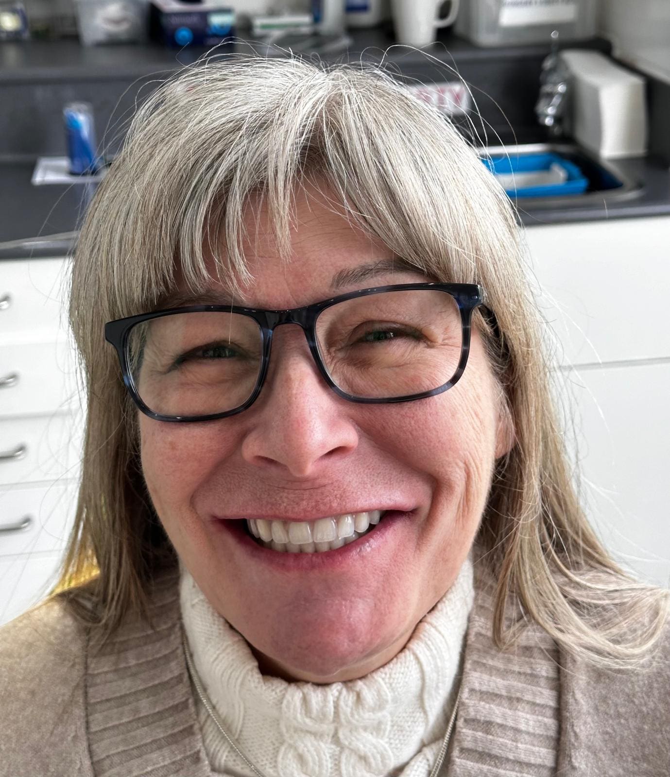 A woman with glasses smiling for the camera.