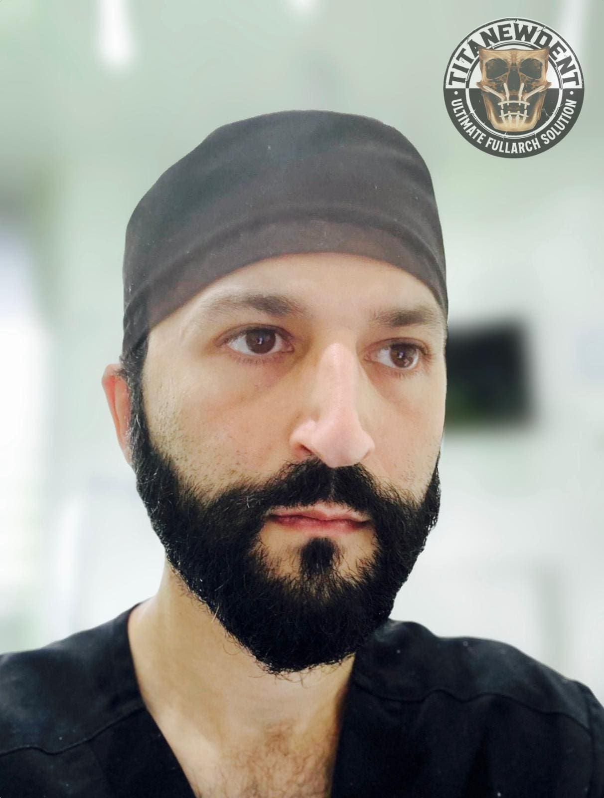 A man with beard and black hat in front of a mirror.